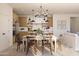 Open-concept dining area with a modern chandelier and view into the adjacent kitchen at 7976 W Griswold Rd, Peoria, AZ 85345