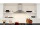 Well-appointed kitchen featuring open shelving, subway tile backsplash, and stainless steel range hood at 7994 W Griswold Rd, Peoria, AZ 85345