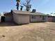 Spacious backyard with a stucco home, compact landscaping, and dual palm trees in the horizon at 808 N 67Th Ln, Phoenix, AZ 85043
