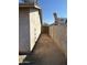 View of the side yard between the house and block wall with a ladder leaning on the wall at 808 N 67Th Ln, Phoenix, AZ 85043