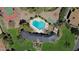 Aerial view of a community pool shaped like a heart, surrounded by mature trees and well-kept grounds at 9059 N Arroya Grande Dr, Phoenix, AZ 85028