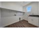 Laundry room features a window, shelving, utility sink and gray countertop at 921 E Desert Ln, Phoenix, AZ 85042