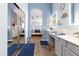Bathroom with dual sinks, illuminated mirrors, and a bathtub with shutters at 9654 E Pantera Ave, Mesa, AZ 85212