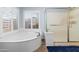 Clean, bright bathroom featuring a tub and glass-enclosed shower at 9654 E Pantera Ave, Mesa, AZ 85212