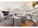 Open-concept kitchen boasts a large island with seating, stainless steel appliances, and natural light at 9654 E Pantera Ave, Mesa, AZ 85212
