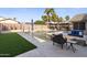 Backyard pool with a sun shelf, waterfall feature, and a covered outdoor kitchen at 9654 E Pantera Ave, Mesa, AZ 85212