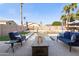Backyard oasis featuring a pool with a fire pit, lush landscaping, and comfortable seating at 9654 E Pantera Ave, Mesa, AZ 85212