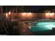 Backyard pool featuring a swim up table, tiki torches lining the perimeter, and lush landscaping at 9654 E Pantera Ave, Mesa, AZ 85212