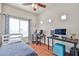 Bedroom has a white ceiling fan, work space, and a window with natural light and light colored walls at 10022 W Luxton Ln, Tolleson, AZ 85353