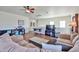 Well lit living room with wood floors, a large sectional sofa, and game area at 10022 W Luxton Ln, Tolleson, AZ 85353