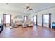 Open living room features neutral wall colors, hardwood floors, and a sofa set with decorative pillows at 10022 W Luxton Ln, Tolleson, AZ 85353