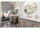 Bright bathroom with elegant vanities, gold hardware, decorative mirrors, and a modern glass-enclosed shower at 10056 E San Bernardo Dr, Scottsdale, AZ 85258