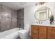 Stylish bathroom features a tub with gray tile, a toilet, and a wood vanity with white countertop and modern fixtures at 10056 E San Bernardo Dr, Scottsdale, AZ 85258