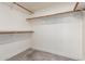 Empty walk-in closet with white walls, gray tile floor, and wooden rods on shelving at 10056 E San Bernardo Dr, Scottsdale, AZ 85258