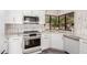 Modern kitchen featuring white cabinetry, marble countertops, stainless appliances, and lots of natural light at 10056 E San Bernardo Dr, Scottsdale, AZ 85258