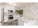Well-designed kitchen featuring white cabinets, marble countertops, and modern appliances at 10056 E San Bernardo Dr, Scottsdale, AZ 85258