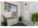 Bright shower with white marble tile, a black pebble floor, and a window creates a luxurious and spa-like feel at 10056 E San Bernardo Dr, Scottsdale, AZ 85258