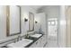 Elegant bathroom with double sinks, black countertops, tiled floors, and an adjacent bath at 1018 W Kaler Dr, Phoenix, AZ 85021