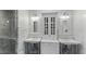 Bright bathroom featuring double sinks, marble countertops, and a glass shower with elegant fixtures at 1018 W Kaler Dr, Phoenix, AZ 85021