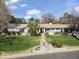 Expansive front lawn and home exterior showcasing mature trees, lush landscaping, and stone accents for added curb appeal at 1018 W Kaler Dr, Phoenix, AZ 85021