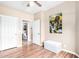 Bright bedroom featuring wood-look floors and a doorway to an ensuite bathroom at 10960 E Monte Ave # 257, Mesa, AZ 85209