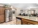 Open kitchen featuring stainless steel appliances, stone countertops, and a large sink overlooking the living area at 10960 E Monte Ave # 257, Mesa, AZ 85209