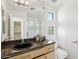 Bathroom with granite counters, a vessel sink, and access to walk-in closet and stand-up shower at 11097 Quinn Dr, Goodyear, AZ 85338