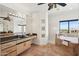 Bright bathroom boasts a large mirror, granite counters, a soaking tub with tile surround, and natural light at 11097 Quinn Dr, Goodyear, AZ 85338