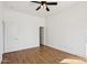 Bright bedroom features laminate wood flooring, a ceiling fan, and a door to walk-in closet at 11097 Quinn Dr, Goodyear, AZ 85338