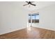 Bright bedroom features laminate wood flooring, a ceiling fan, and large picture windows at 11097 Quinn Dr, Goodyear, AZ 85338