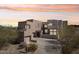 Modern desert home with custom architecture, a spacious driveway, and natural desert landscaping at 11097 Quinn Dr, Goodyear, AZ 85338