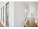 Long hallway featuring sleek hardwood floors, recessed lighting, and large windows for plenty of natural light at 11097 Quinn Dr, Goodyear, AZ 85338