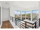 Hallway with hardwood floors, steel railings, and large windows with a view of the outdoor pool and landscape at 11097 Quinn Dr, Goodyear, AZ 85338