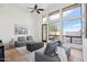 Modern living room with floor-to-ceiling windows, neutral color palette and tile flooring at 11097 Quinn Dr, Goodyear, AZ 85338