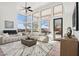 Bright living room with high ceilings, large windows, neutral furniture, and tile floors offering a modern, comfortable space at 11097 Quinn Dr, Goodyear, AZ 85338