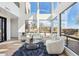 A modern living room with soaring windows, neutral color palette, tile floors, and stylish furnishings exudes contemporary elegance at 11097 Quinn Dr, Goodyear, AZ 85338