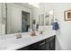 Bright bathroom with double sinks, dark cabinets, and a large mirror at 11558 W Levi Dr, Avondale, AZ 85323