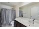 Bathroom featuring dark cabinets, a white counter, and a shower with a silver shower curtain at 12018 W Taylor St, Avondale, AZ 85323