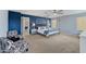 Spacious bedroom with sitting area, blue accent wall, and a four-poster bed illuminated by a ceiling fan at 12018 W Taylor St, Avondale, AZ 85323