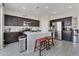 Modern kitchen featuring dark wood cabinetry, stainless steel appliances, and a granite island with seating at 12018 W Taylor St, Avondale, AZ 85323