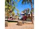 Community playground featuring colorful slides and play equipment with mature trees and seating areas on a sunny day at 12018 W Taylor St, Avondale, AZ 85323