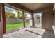 Cozy back patio featuring brick pavers, red curtains, and an artificial grass yard at 12221 W Locust Ln, Avondale, AZ 85323