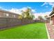 Expansive backyard featuring artificial grass, rock landscaping, and block wall fencing at 12221 W Locust Ln, Avondale, AZ 85323