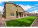 Large backyard featuring artificial grass, rock landscaping, and exterior home view at 12221 W Locust Ln, Avondale, AZ 85323