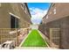 Narrow backyard featuring artificial grass, rock landscaping, and secure fencing at 12221 W Locust Ln, Avondale, AZ 85323