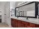 Bathroom vanity with double sinks, dark wood cabinetry, and a framed mirror at 12221 W Locust Ln, Avondale, AZ 85323