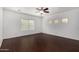 Bedroom with dark wood-look floors, ceiling fan, and multiple windows for natural light at 12221 W Locust Ln, Avondale, AZ 85323