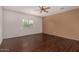 Bedroom with dark wood-look floors, natural light and tan accent wall at 12221 W Locust Ln, Avondale, AZ 85323