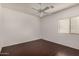 Simple bedroom with a ceiling fan, wood-look flooring, and a window with blinds at 12221 W Locust Ln, Avondale, AZ 85323