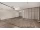 Well-lit garage featuring ample storage cabinets and smooth concrete flooring at 12221 W Locust Ln, Avondale, AZ 85323